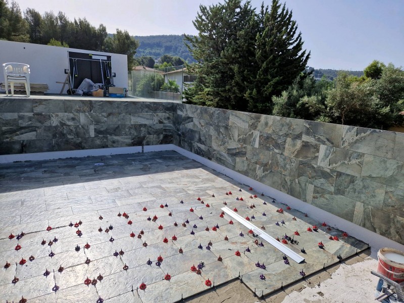 Piscine débordement avec carrelage en pierre naturelle à La Ciotat 