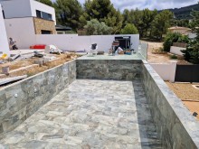Piscine débordement avec carrelage en pierre naturelle à La Ciotat